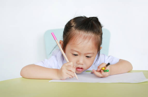 istock Asian child in school uniform with pencil writing on table isolated on white background. 849744188