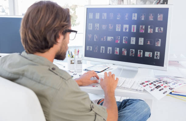 Photo editor looking at thumbnails on computer Photo editor looking at thumbnails on computer at his desk photo editing screen stock pictures, royalty-free photos & images