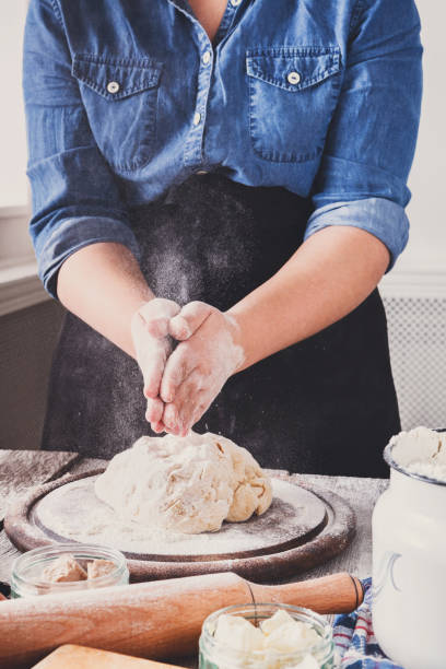 istock Woman baker knead and sprinkle yeast dough with eggs and flour 849749436