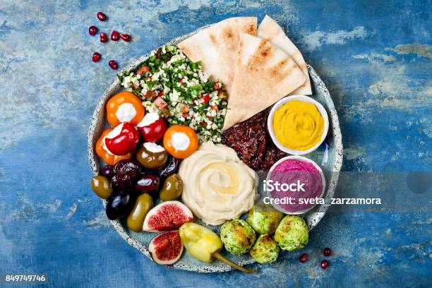 Middle Eastern Meze Platter With Green Falafel Pita Sun Dried Tomatoes Pumpkin And Beet Hummus Olives Stuffed Peppers Tabbouleh Figs Mediterranean Appetizer Party Idea Stock Photo - Download Image Now
