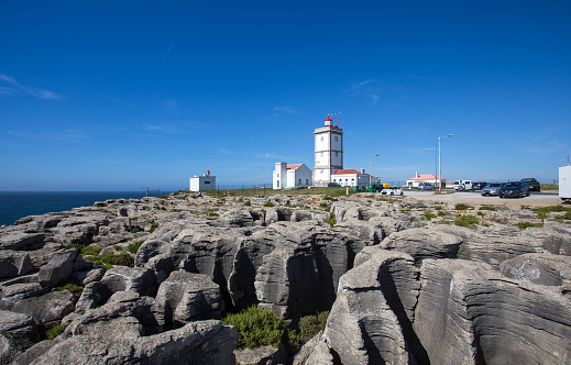 Rock view background with the Lighthouse of Cape Carvoeiro, Peniche, Portugal, Europe / sea rocks background / black rocks