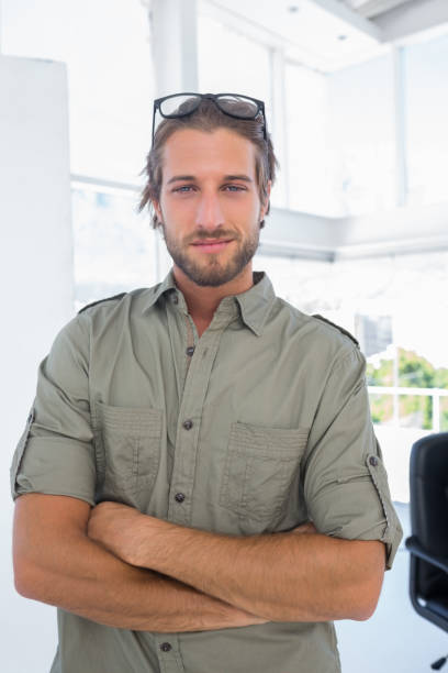 istock Smiling man in creative office with arms folded 849752558
