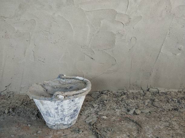 plaster bucket near unfinish plaster wall,with copy space inside - unfinish imagens e fotografias de stock