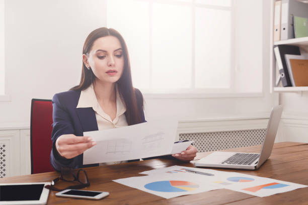 istock Business woman reading document at office desktop 849757210