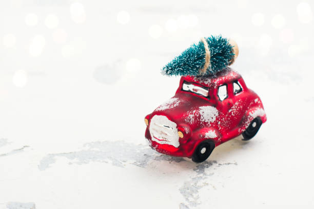 istock Miniature red car carrying fir tree on Christmas background 849757438