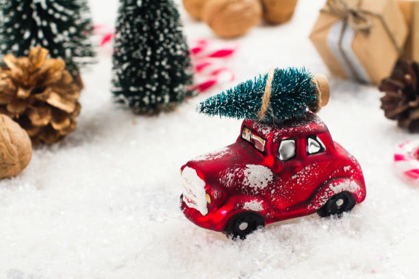 istock Miniature red car carrying fir tree on Christmas background 849757614