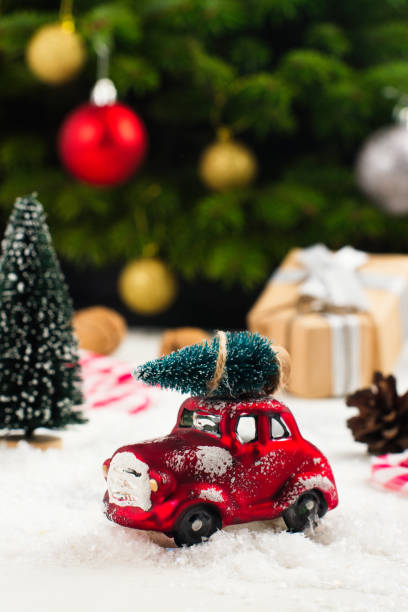 istock Miniature red car carrying fir tree on Christmas background 849758462