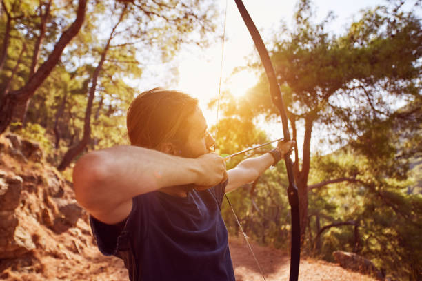 istock a young man is preparing to shoot with the bow in the forest 849764106