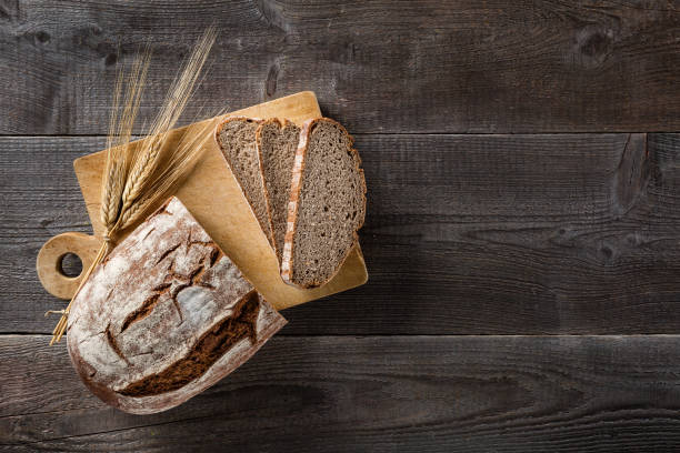 sliced baked bread on cutting board - pão fresco imagens e fotografias de stock