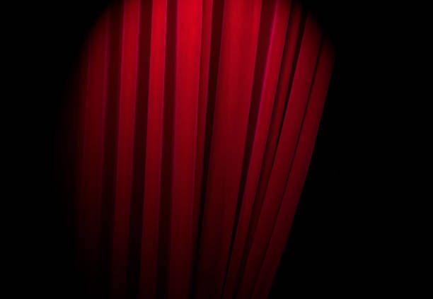 istock Red curtains at a theatre with half light for text or other ideas 849765050