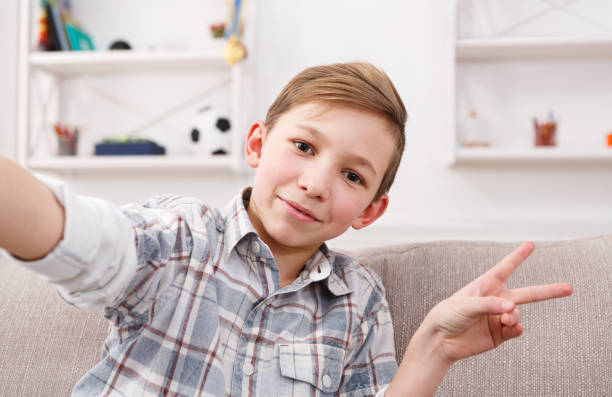 istock Male child taking selfie on phone at home 849769590