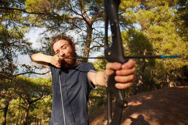 istock a young man is preparing to shoot with the bow in the forest 849774272