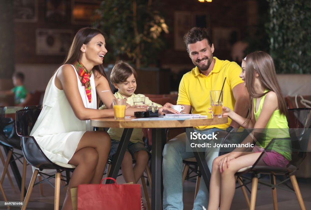 Schöne junge Familie im Café warten auf Bestellung - Lizenzfrei Familie Stock-Foto