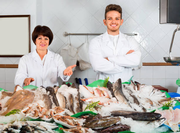 istock Two sellers posing near display with frozen fish 849781682