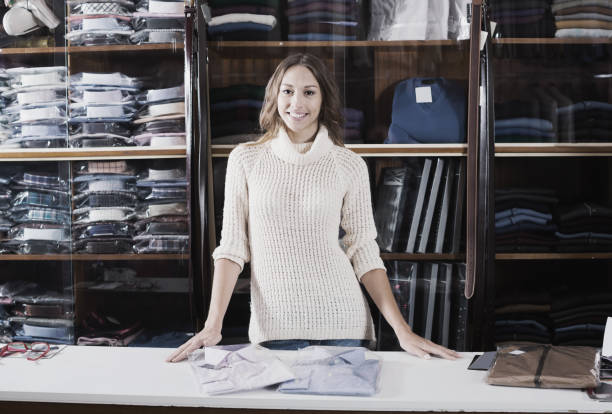 istock Young woman seller displaying diverse shirts 849781886