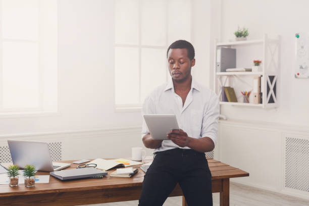 istock Serious black businessman in modern office, work with tablet 849795248