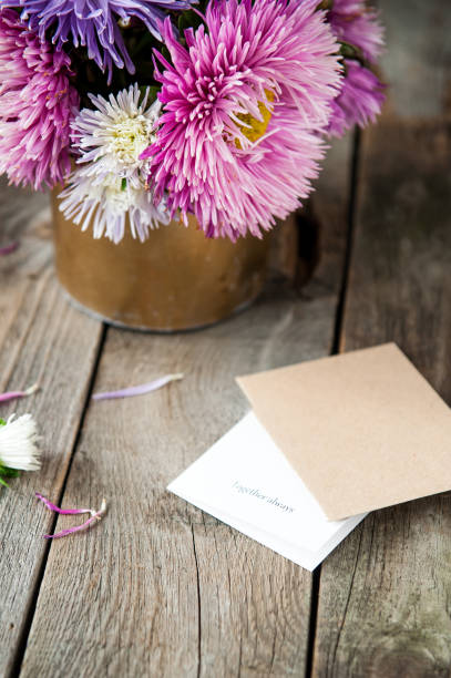 istock Multicolor aster flowers bouquet, card with words Together always, craft paper envelope on rustic wooden table. Postcard mock up. Autumn flowers. Selective focus. Space for text 849800792