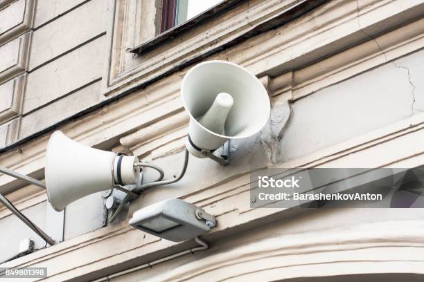 White Megaphones On Old Building Stock Photo - Download Image Now - Amplifier, Arts Culture and Entertainment, Blue