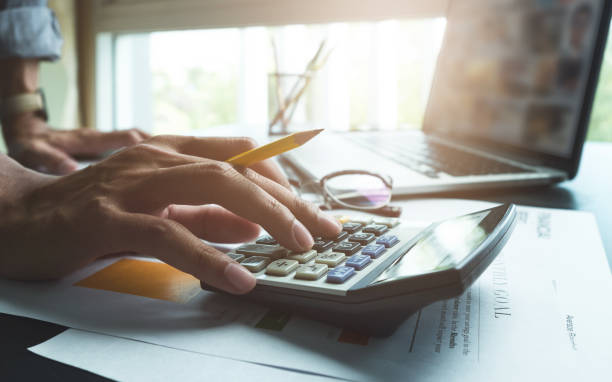 istock Business man working at office with calculator laptop computer and documents on his desk 849801636