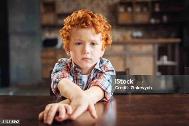 Photo libre de droit de Rousse Sennuie Petit Garçon Assis À Table banque d'images et plus d'images libres de droit de Petits garçons - Petits garçons, Enfant, Cheveux roux