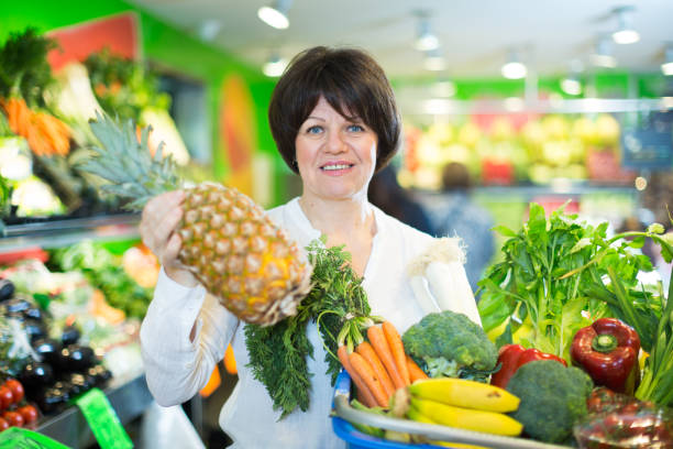 istock Middle aged woman with basket choosing fruits 849819128