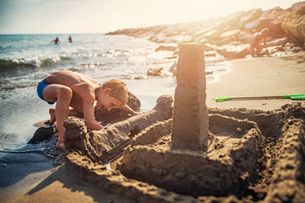 istock Little boy building sandcastle on italian beach 849825948