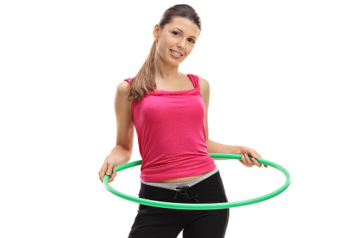 Female athlete exercising with a hula-hoop isolated on white background