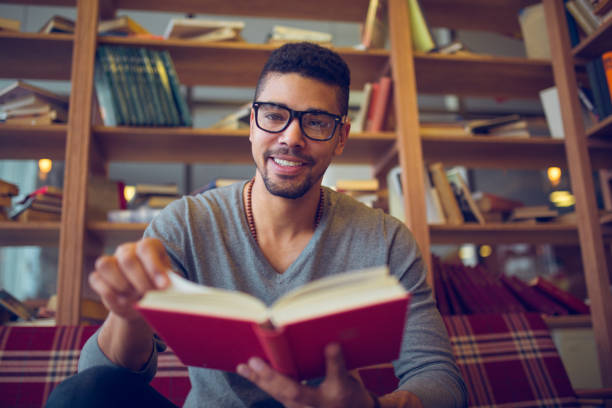 istock Smiling African American student  enjoying book reading in library 849837262
