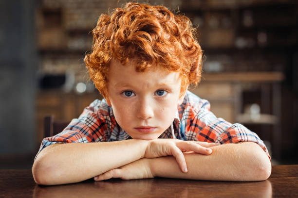 istock Upset little kid resting his chin on his folded arms 849837348