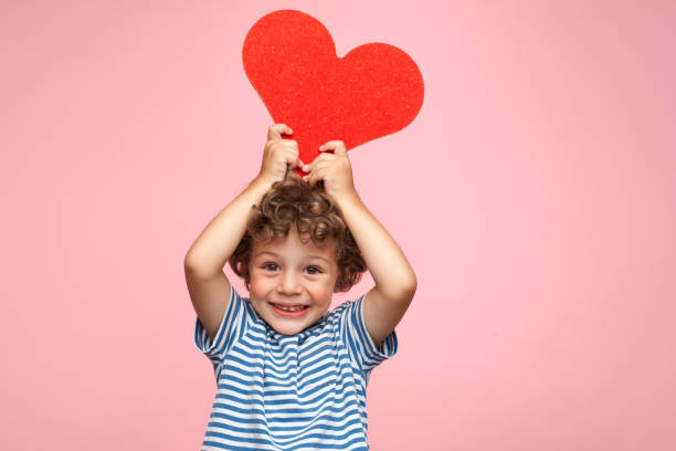 charming kid posing with heart - valentines day red photography indoors imagens e fotografias de stock