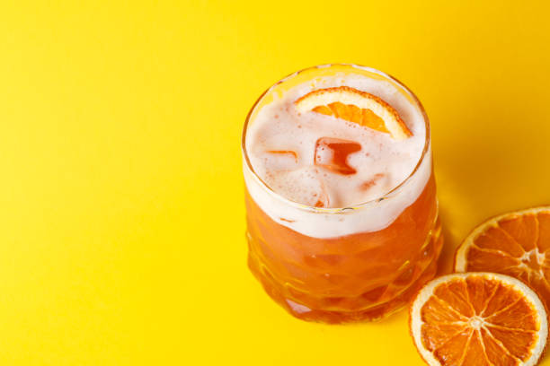 Orange cocktail with citron on colorful background