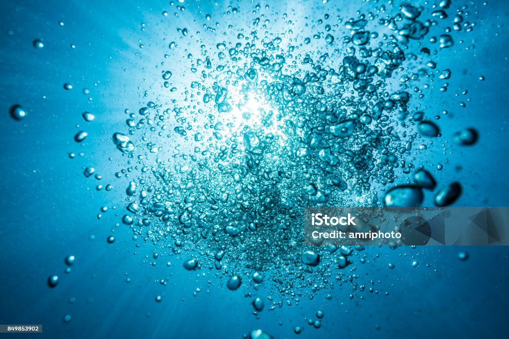 diving bubbles underwater against surface with sunlight many bubbles of oxygen in backlight under water rising towards the surface in backlight sun Water Stock Photo