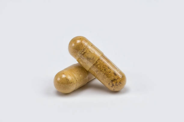 vitamines naturelles dans des capsules sur fond blanc - editorial label man made material healthcare and medicine photos et images de collection