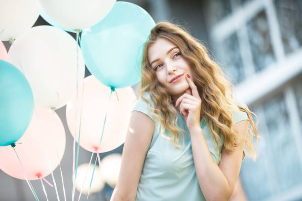 istock beautiful woman with flying multicolored balloons 849857880