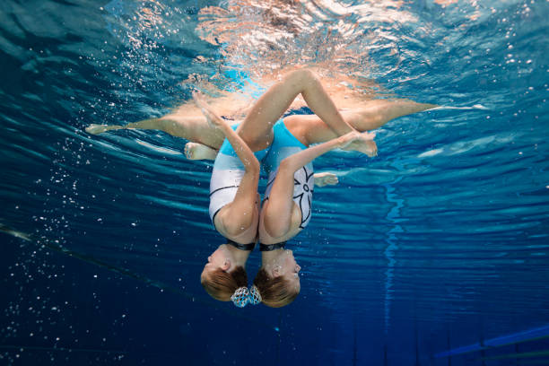 istock Women in Sport - snychronized swimming underwater pose 849858152