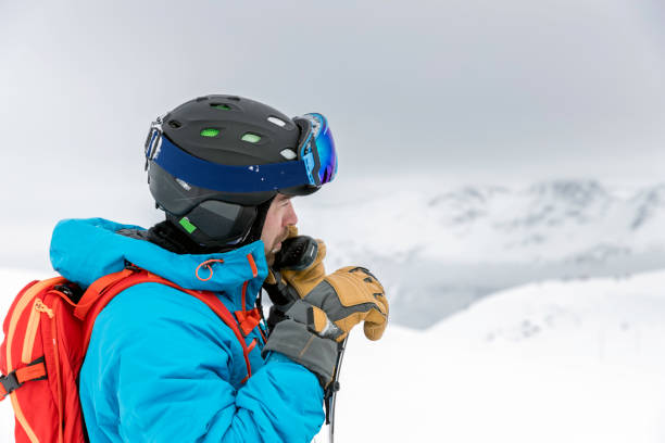Skier Snowboarder Using Walkie Talkie in Backcountry Area Skier Snowboarder Using Walkie Talkie in Backcountry Area ski patrol photos stock pictures, royalty-free photos & images