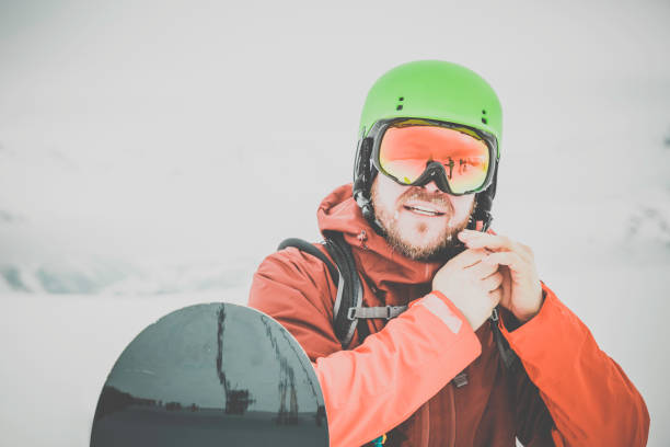 istock Happy Snowboarder Gearing Up Outdoor During Snowstorm 849859572