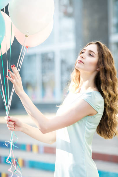 istock beautiful woman with flying multicolored balloons 849861794