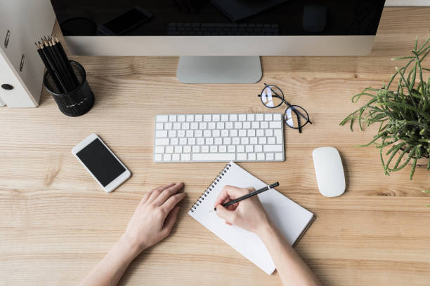 istock woman writing in notebook at workplace 849864070