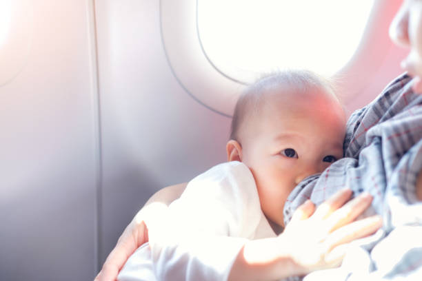 азиатская мать кормит грудью милый маленький азиатский 18 месяцев малыш мальчик ребенка на самолете - chest fly стоковые фото и изображения