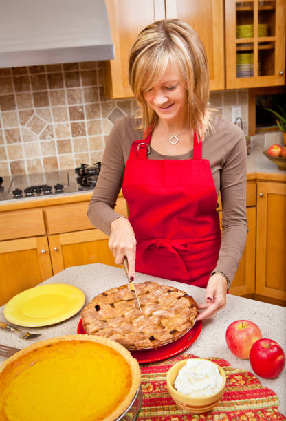 istock Woman Cutting Apple Pie Preparing Thanksgiving and Christmas Dinner 849880948