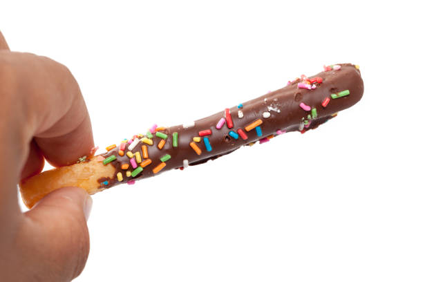 istock hand holding colorful doughnut Stick isolated on white background 849912120