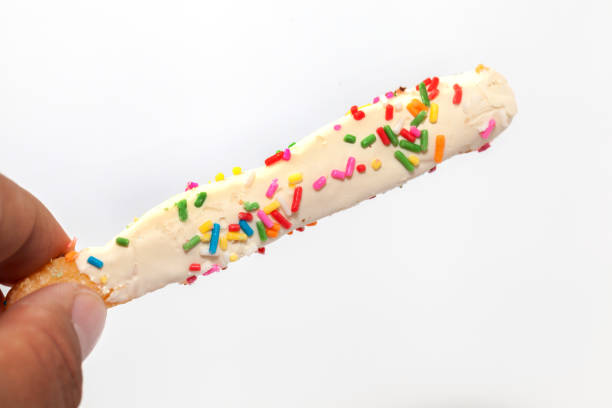 istock hand holding colorful doughnut Stick isolated on white background 849912370