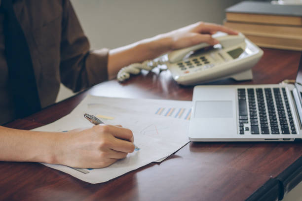 istock Close up businessman analyzing graph document with laptop and telephone. 849921118