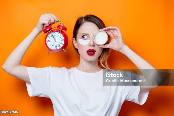 Woman Using Eye Patch For Her Eyes And Care Lips On Orange Background Stock Photo - Download Image Now