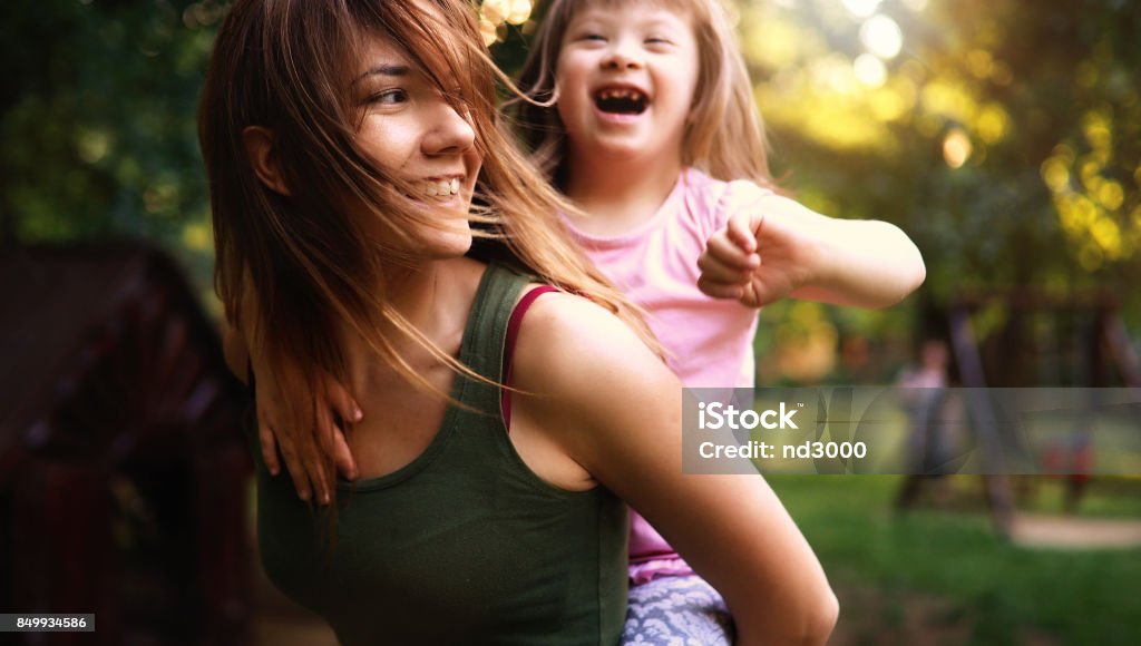 Niña con especial necesita disfrutar de pasar tiempo con la madre - Foto de stock de Diversidad funcional libre de derechos