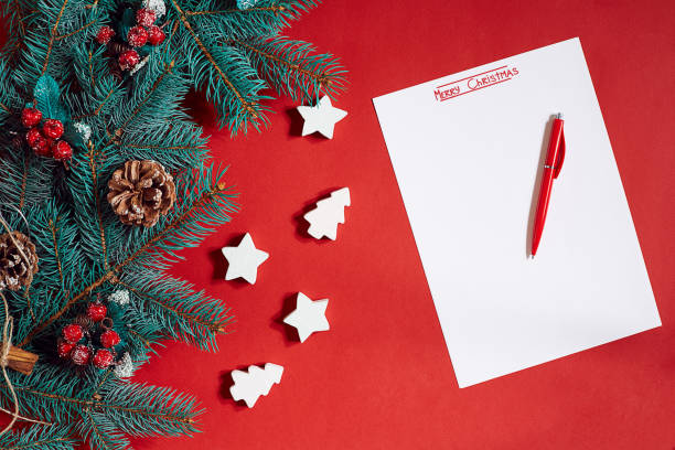 istock Red pen and notepad on red table decorated with a fir branch. The background for the text 849935200