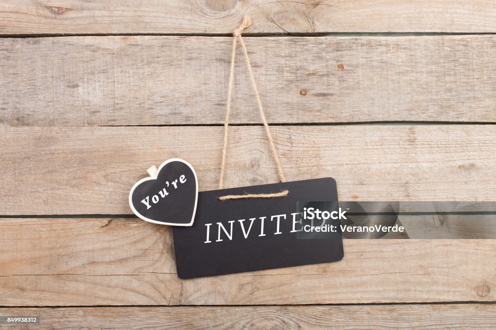 Blackboards with text "You're invited" on wooden background Guest Stock Photo