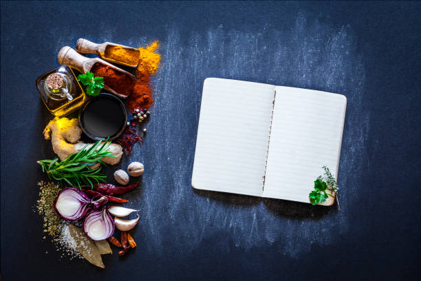 istock Cookbook with spices and herbs on dark kitchen table 849938946