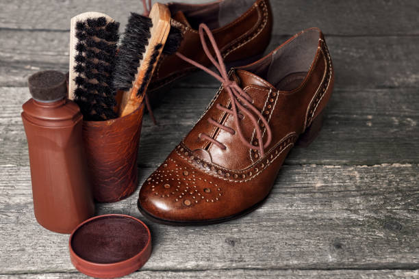 istock Shoe wax and brushes on wooden surface 849940504